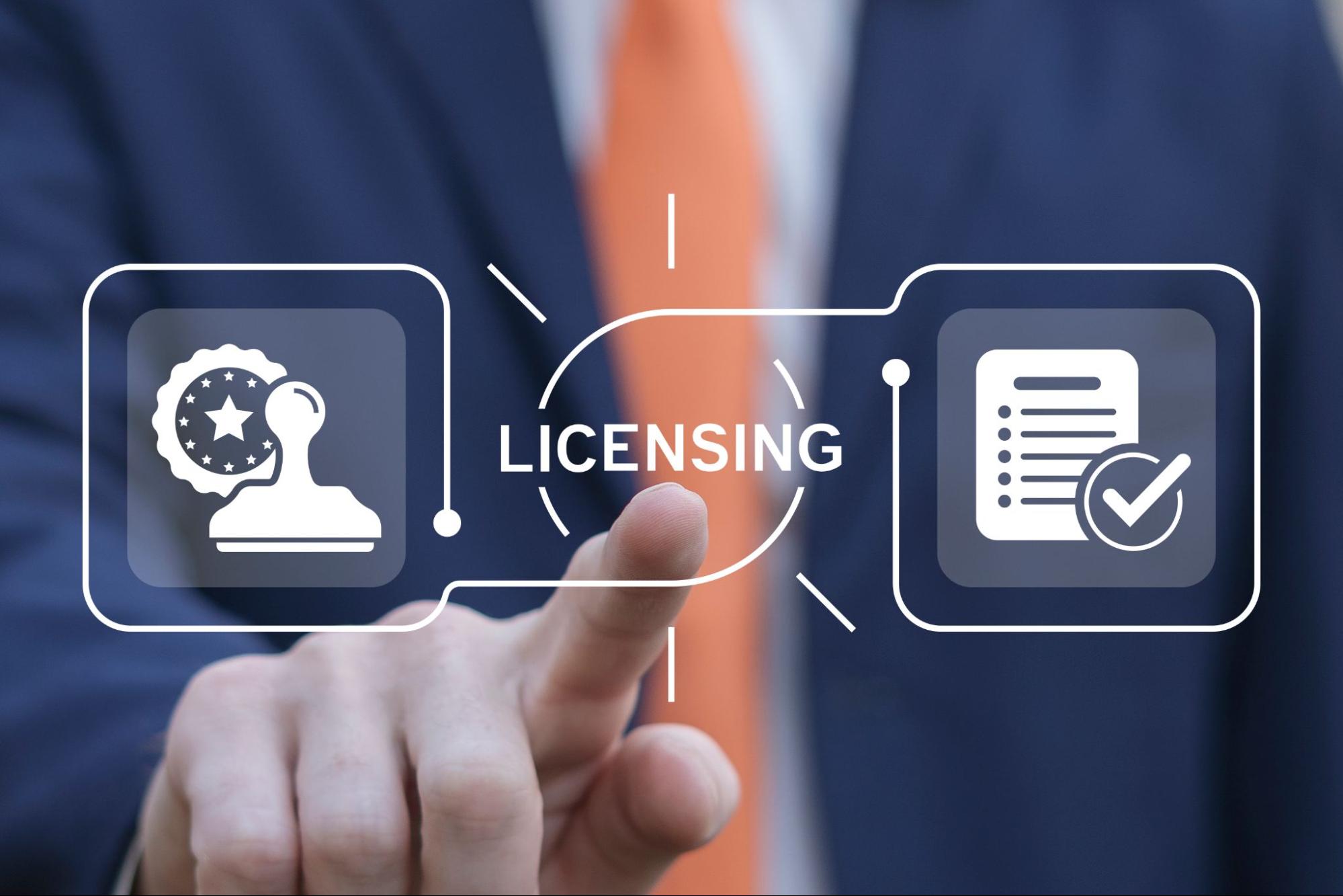 Business man using virtual touch interface presses word: LICENSING.